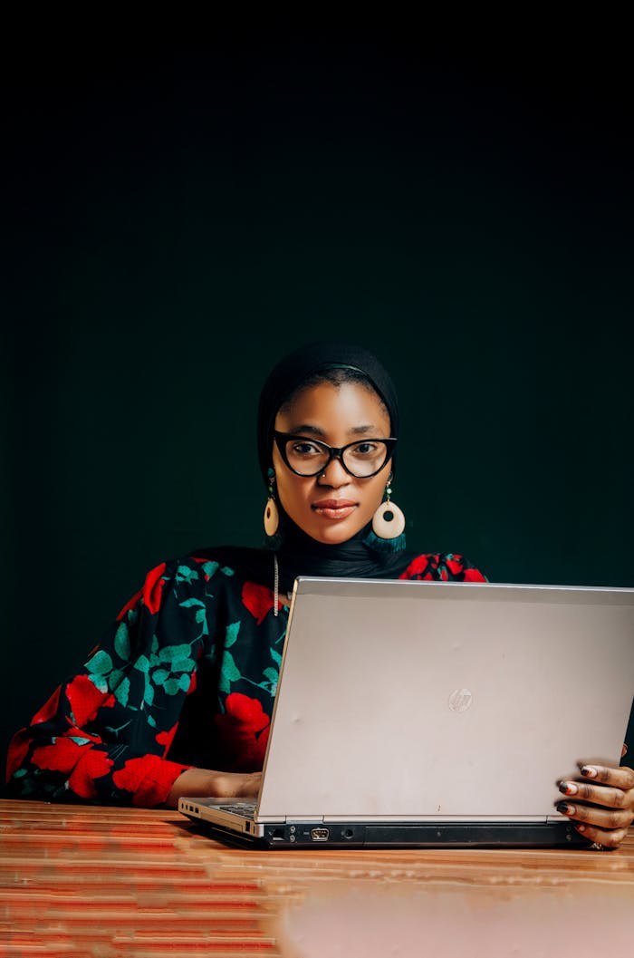 Portrait of an African woman using a laptop in a vibrant outfit. Business and creativity in Nigeria.