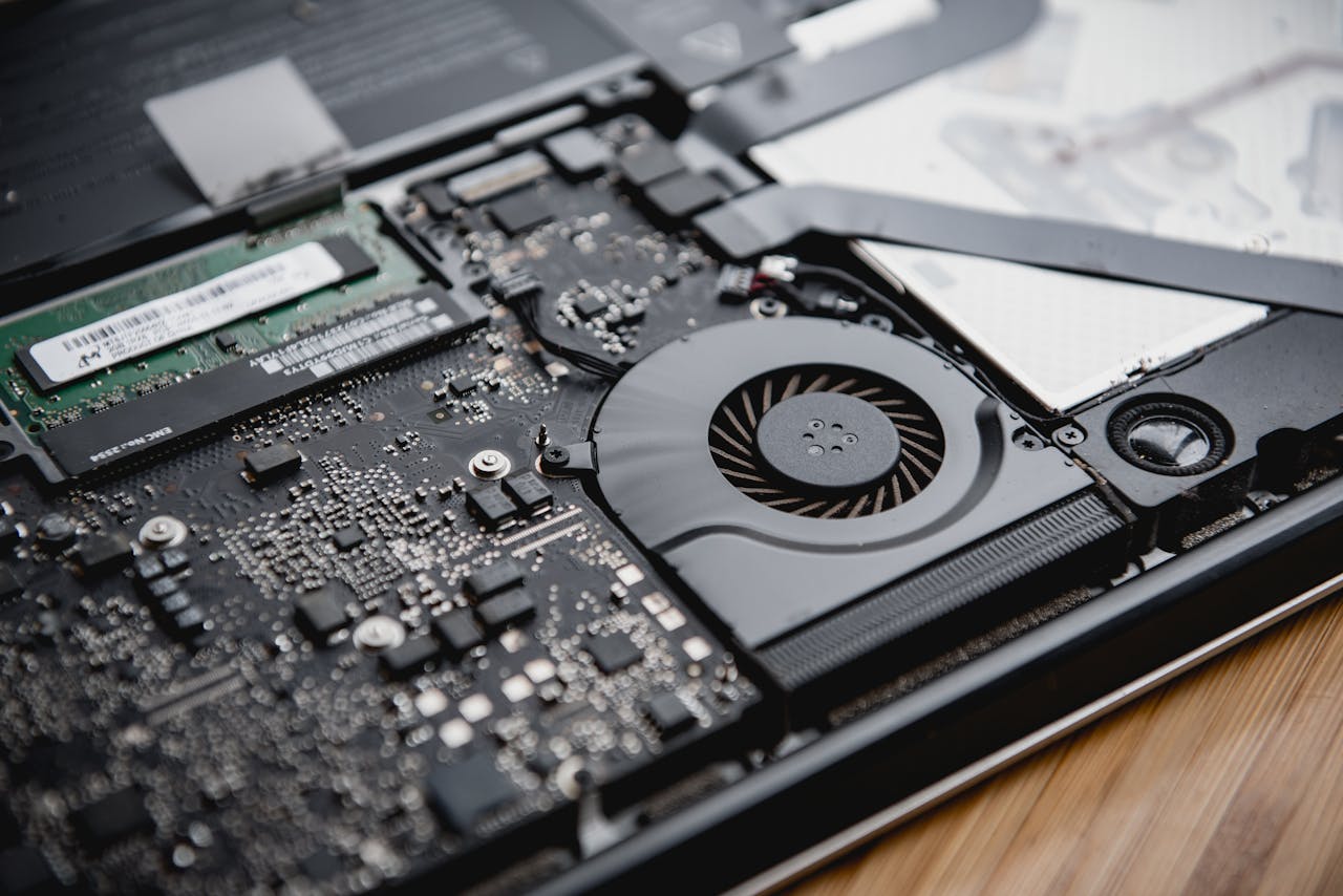 Detailed view of a laptops internal circuitry and cooling fan showcasing technology and engineering.